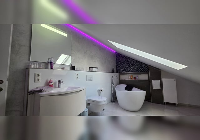 Freistehende Badewanne mit Ambient-Licht und Dachfenster